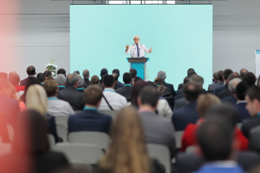 Medical professional speaking in front of a large group of people