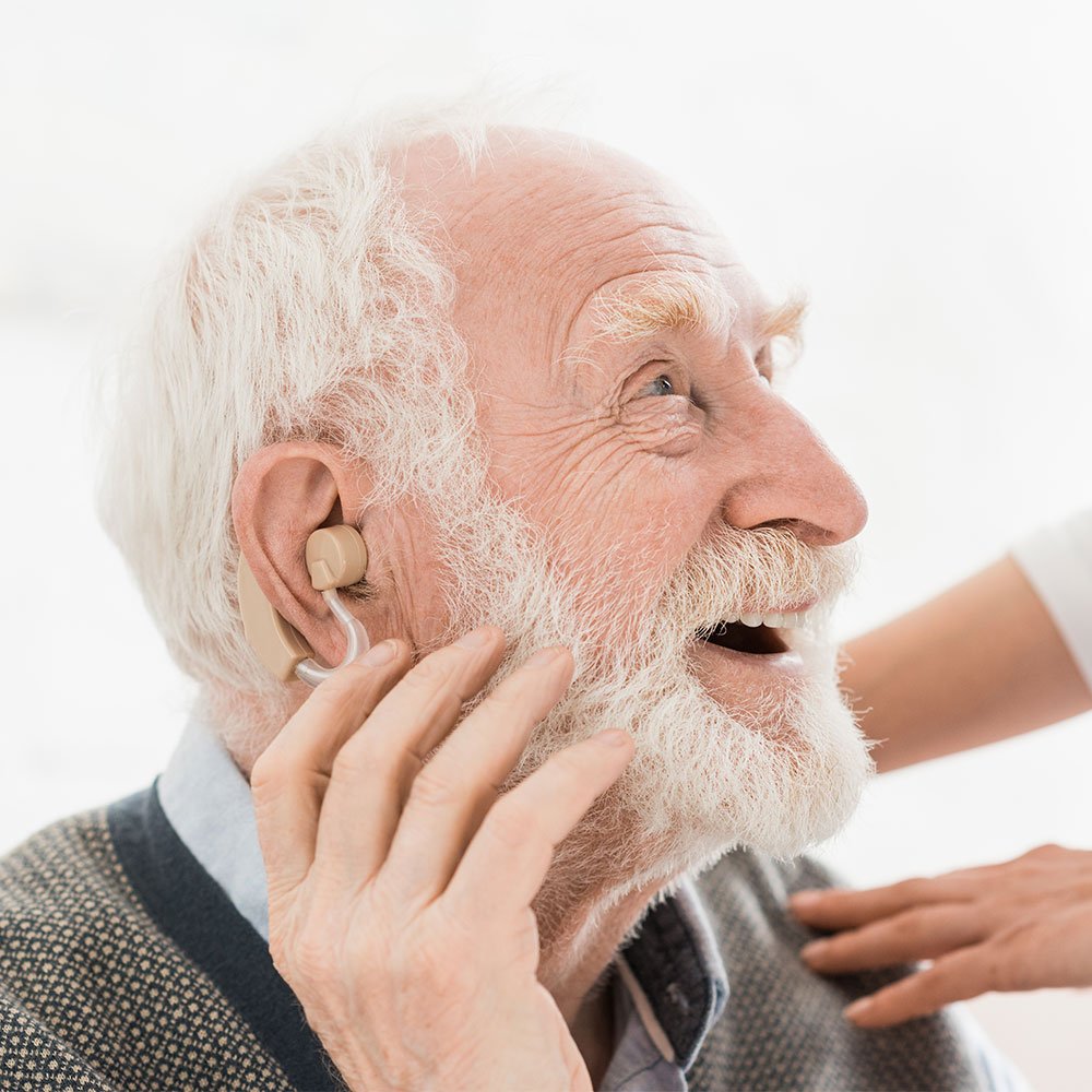 Cheerful-looking senior man with hearing aid in ear